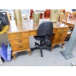 A WALNUT KNEEHOLE DESK WITH INLET LEATHER TOP, SEVEN DRAWERS, ON EIGHT SHELL CARVED CABRIOLE