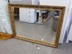 A LARGE OBLONG BEVELLED EDGE WALL MIRROR, IN FOLIATE EMBOSSED GILT FRAME, 3' x 3'9"