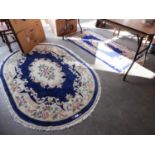 TWO CHINESE RUGS, ONE CIRCULAR AND ONE OBLONG, WITH ROYAL BLUE AND FLORAL PATTERN