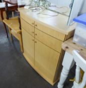 A PALE BEECH, SLIGHTLY BOW FRONTED CABINET WITH TWO LONG DRAWERS OVER A CUPBOARD WITH TWO DOORS