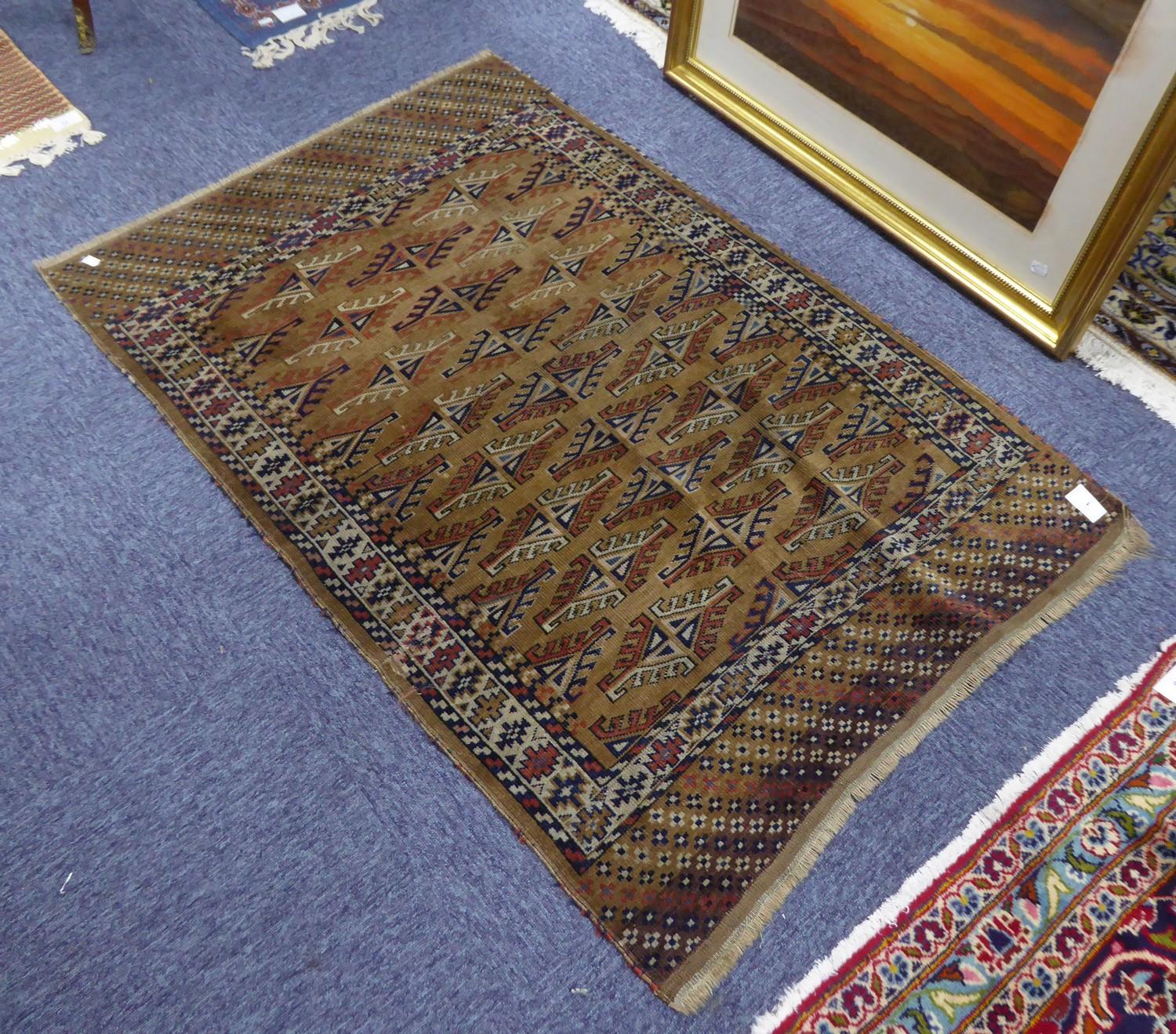 OLD TURKOMAN BOKHARA RUG, with five rows of guls on a faded brown field, white and patterned