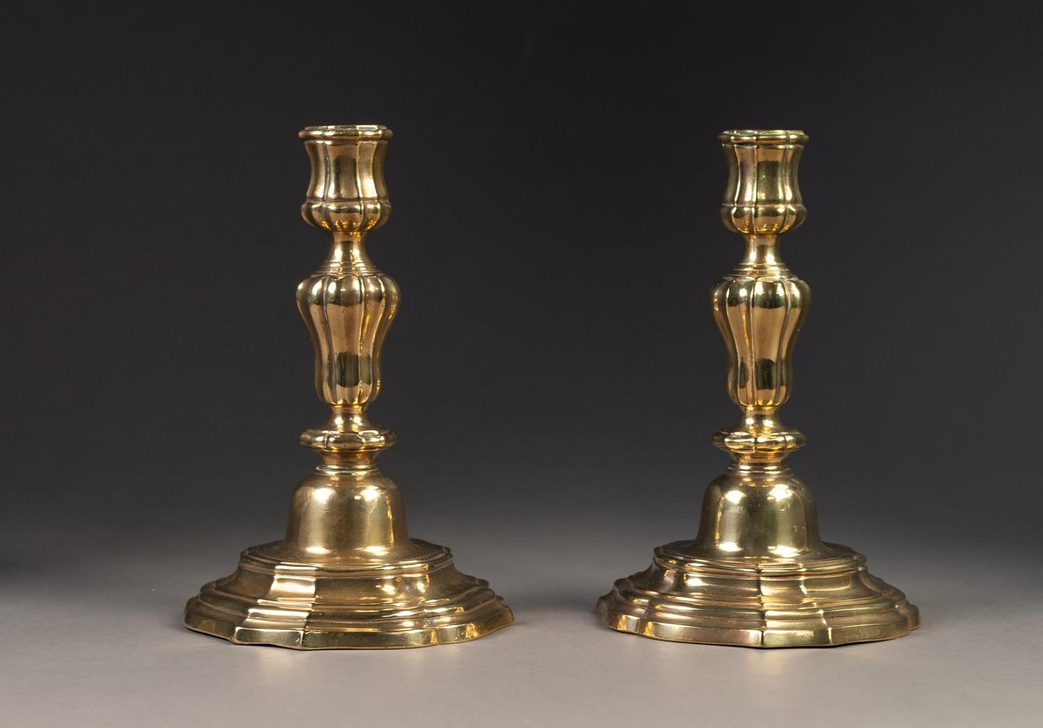 PAIR OF ANTIQUE BRASS CONTINENTAL CANDLESTICKS, with campana shaped sconces, lobed melon shaped