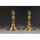 PAIR OF ANTIQUE BRASS CONTINENTAL CANDLESTICKS, with campana shaped sconces, lobed melon shaped