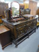 AN EDWARDIAN LARGE CARVED OAK SIDEBOARD, WITH PANELLED LEDGE BACK, THREE DRAWERS ABOVE THREE