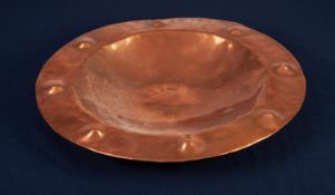 ARTS AND CRAFTS PLANISHED COPPER PLAQUE, of circular form with dished centre and raised, circular