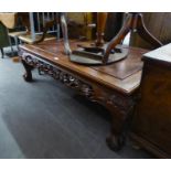 AN ORIENTAL MAHOGANY LARGE OBLONG COFFEE TABLE WITH DRAGON CARVED AND PIERCED APRON, ON FOUR MASK