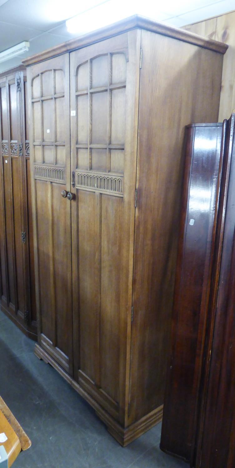 A PRIORY STYLE OAK AND PLY TWO DOOR WARDROBE