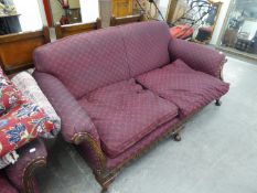 AN EDWARDIAN FEATHER STUFFED THREE SEATER SETTEE AND ARMCHAIR, UPHOLSTERED IN PURPLE FABRIC,