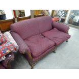 AN EDWARDIAN FEATHER STUFFED THREE SEATER SETTEE AND ARMCHAIR, UPHOLSTERED IN PURPLE FABRIC,