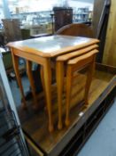 A NEST OF THREE LIGHT WOOD COFFEE TABLES WITH GLASS PROTECTORS