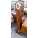 A WALNUT CASED ART DECO GRANDDAUGHTER CLOCK, WITH STRIKING AND CHIMING SPRING DRIVEN MOVEMENT,