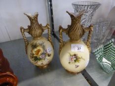 A PAIR OF AUSTRIAN CHINA TWO HANDLED VASES PAINTED WITH FLOWERS ON AN IVORY GROUND (ONE AS FOUND)
