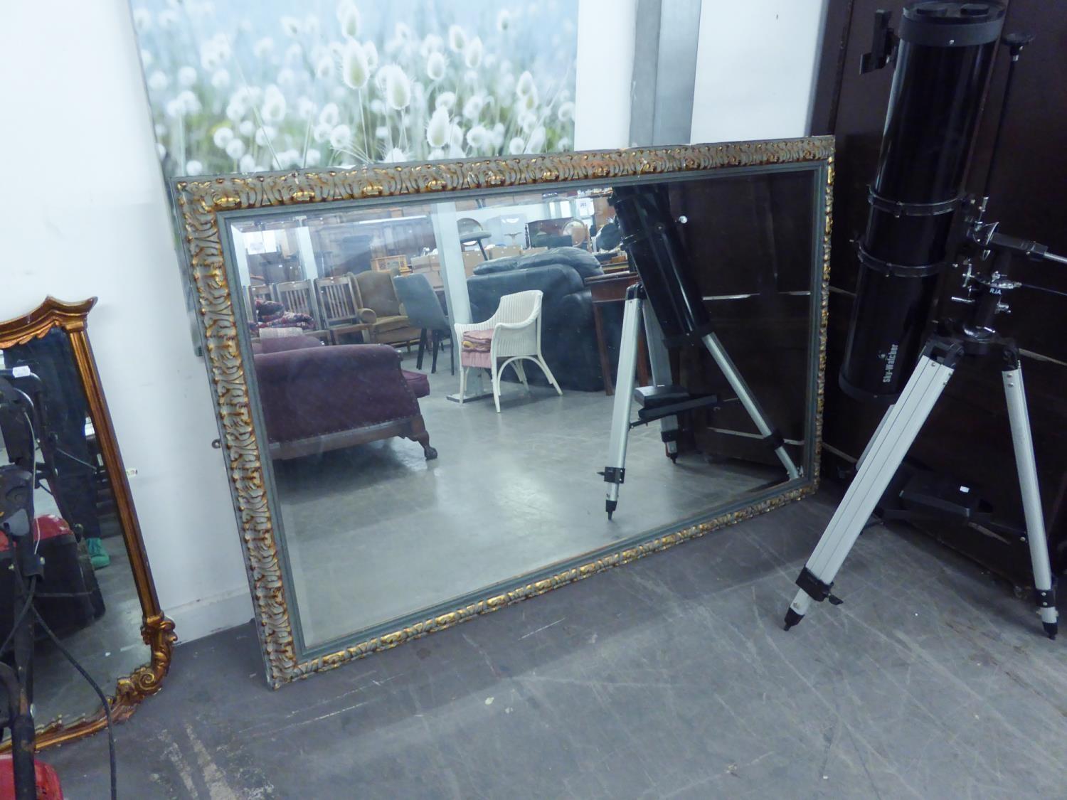 A LARGE OBLONG BEVELLED EDGE WALL MIRROR IN EBONISED GILT FRAME, 5?4? WIDE