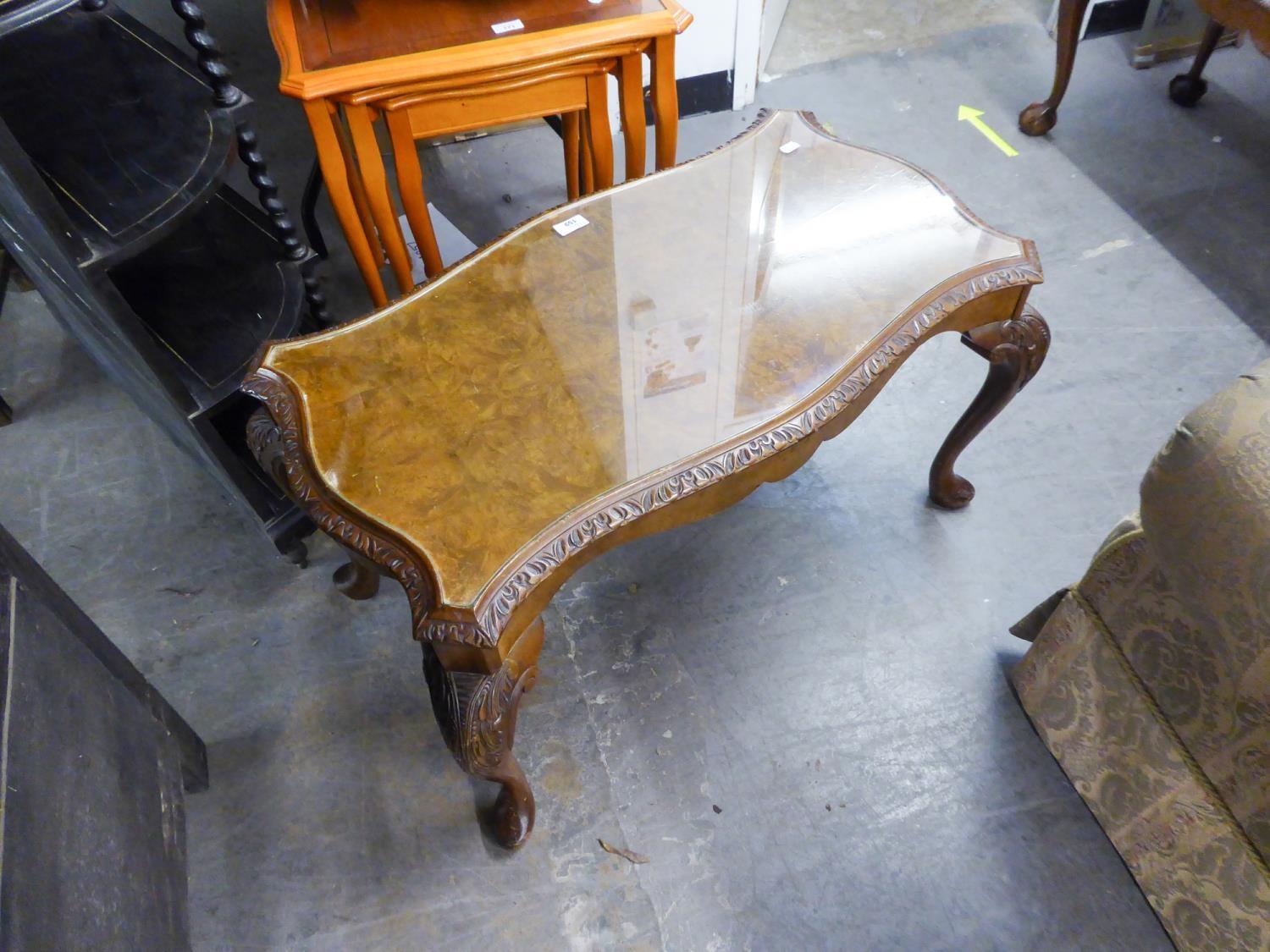 A CARVED AND FIGURED WALNUT SERPENTINE OBLONG COFFEE TABLE, ON CARVED CABRIOLE LEGS AND THE LOOSE