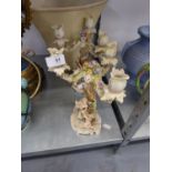A PAIR OF VOLKSTED, GERMAN PORCELAIN THREE BRANCH CANDELABRA, EACH WITH TWO CHERUBS IN FREE