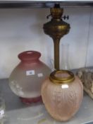 A TALL BRASS OIL TABLE LAMP WITH SMALL PINK GLASS SHADE AND GLASS FUNNEL AND ANOTHER PINK AND