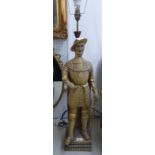 A CARVED WOOD AND GILT DECORATED STANDING FIGURE OF A MAN IN ARMOUR, HIS LEFT HAND RESTING ON HIS