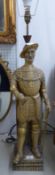 A CARVED WOOD AND GILT DECORATED STANDING FIGURE OF A MAN IN ARMOUR, HIS LEFT HAND RESTING ON HIS