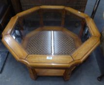 A LARGE WALNUTWOOD OCTAGONAL COFFEE TABLE WITH INSET PLATE GLASS TOP, CANE PANEL UNDER PLATFORM