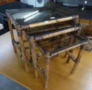 A NEST OF THREE BAMBOO OBLONG COFFEE TABLES, WITH SMOKED GLASS TOPS