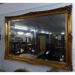 A LARGE OBLONG BEVELLED EDGE WALL MIRROR, IN GILT FRAME