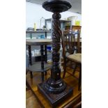 A MAHOGANY TORCHERE STAND WITH CIRCULAR TOP, TURNED AND SPIRALLY FLUTED AND ACANTHUS CARVED
