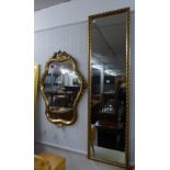 A MODERN GILT FRAMED CARTOUCHE SHAPED WALL MIRROR AND A ROBING MIRROR (2)