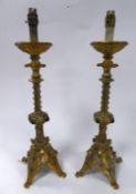 PAIR OF LATE VICTORIAN GOTHIC REVIVAL COLOURED GLASS MOUNTED GILT METAL CANDLESTICKS, converted to