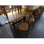 A MODERN PINE OBLONG KITCHEN TABLE AND FOUR ELM LADDER BACK SINGLE CHAIRS WITH RUSH SEATS
