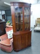 A REPRODUCTION MAHOGANY SHALLOW BOW FRONT STANDING CORNER CUPBGOARD