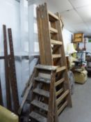 A PAIR OF LARGE WOODEN EASELS (240cm high), A SET OF 10 RUNG WOODEN STEP LADDERS AND A SET OF FIVE