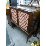 A REPRODUCTION TWO DOOR DRINKS CABINET, DOORS HAVING LATTICE WORK AND RAISED ON TURNED LEGS