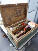 A FITTED WOODEN TOOL TRUNK CONTAINING VARIOUS TOOLS AND FOUR OLD OIL CANS