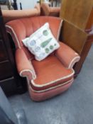 A SMALL SEMI WINGED LOUNGE CHAIR, IN WINE RED FABRIC