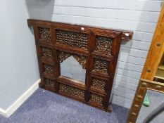 A MIDDLE EASTERN CARVED AND PIERCED DOOR PANEL NOW FITTED WITH CENTRAL MIRROR, 3? SQUARE