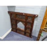 A MIDDLE EASTERN CARVED AND PIERCED DOOR PANEL NOW FITTED WITH CENTRAL MIRROR, 3? SQUARE