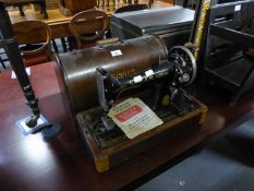 A VINTAGE SINGER MANUAL PORTABLE SEWING MACHINE WITH OAK DOME TOPPED CASE AND A SINGER BUTTONHOLE