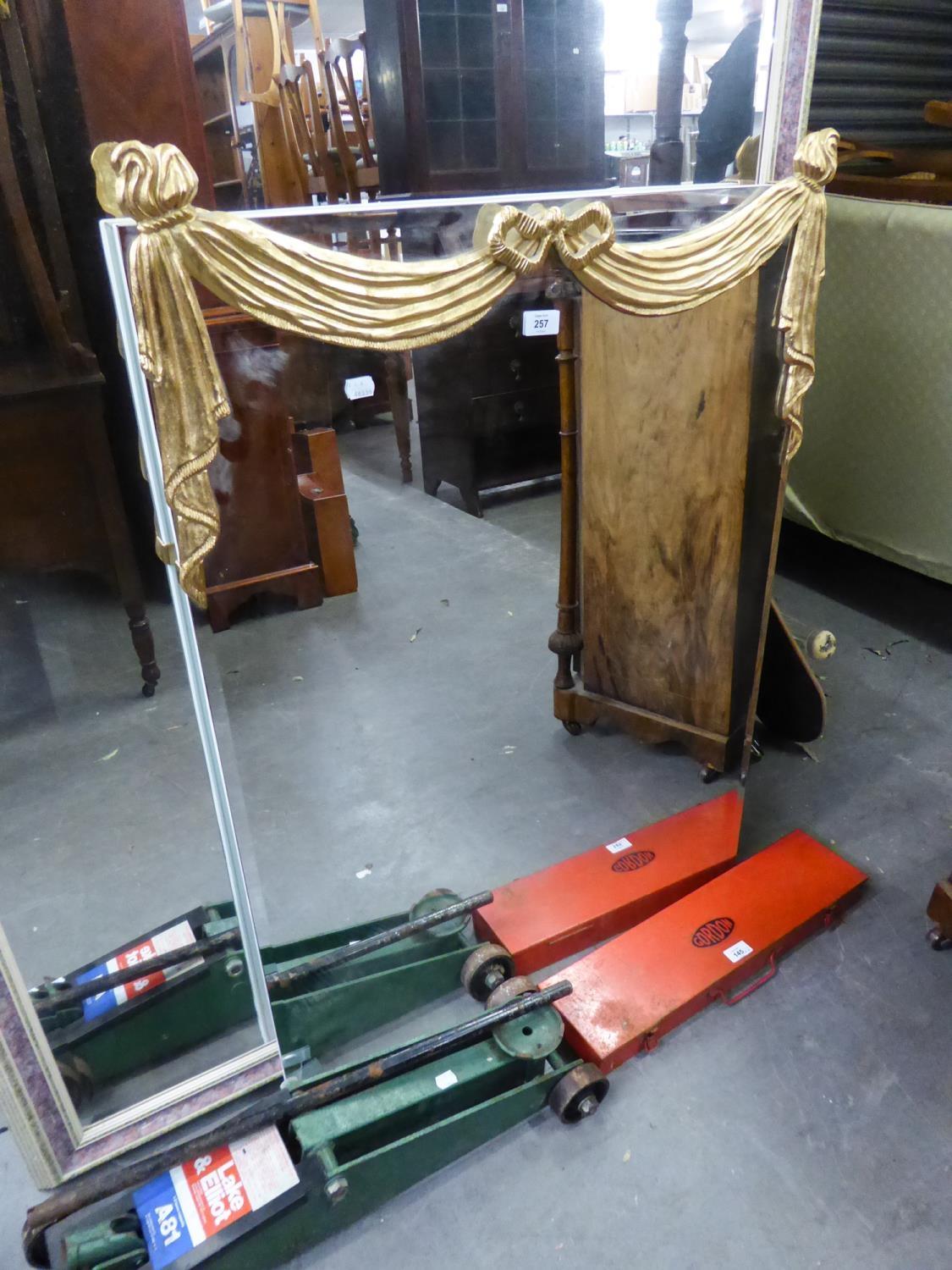 A FRAMELESS RECTANGULAR BEVELLED EDGE WALL MIRROR, WITH GILT RIBBON DECORATION TO THE TOP (101cm x