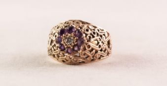 9ct GOLD, DIAMOND AND AMETHYST DRESS RING, the broad, domed and S scroll pierced top surmoutend by a