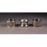 EDWARD VII THREE SILVER NAPKIN RINGS, comprising: A PAIR, repousse with cartouche and foliate