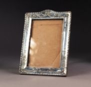 EDWARD VII EMBOSSED SILVER FRONTED DESK TOP PHOTOGRAPH FRAME, of oblong form with ribbon tied bell