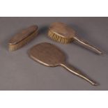 GEORGE V THREE PIECE LADY?S ENGINE TURNED SILVER CLAD DRESSING TABLE HAND MIRROR AND BRUSH SET,