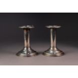 PAIR OF FILLED STERLING SILVER CANDLESTICKS, each with embossed border to the sconce, 4 ½? (11.