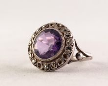 SILVER COLOURED METAL AND MARCASITE RING set with a brilliant cut amethyst, with broad marcasite set