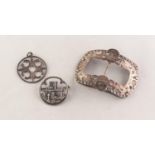 SILVER COLOURED METAL PIERCED OBLONG BUCKLE, 3in (7.6cm); a SILVER CIRCULAR IONA CHURCH BROOCH and a