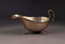 GEORGE V SILVER SAUCE BOAT, of typical form with high scroll handle, slender gadrooned border and