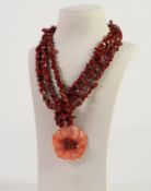 THREE STRAND DARK RED CHIP CORAL BEAD NECKLACE with large red stained carved mother of pearl and