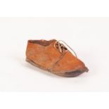 A CURIOSITY IN THE FORM OF AN INFANTS SMALL KID LEATHER SHOE, with laces, the sole with hand written