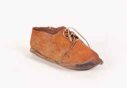 A CURIOSITY IN THE FORM OF AN INFANTS SMALL KID LEATHER SHOE, with laces, the sole with hand written