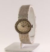 LADY'S 18ct WHITE GOLD WRISTWATCH, with mechanical movement, oval silvered dial with batons, the